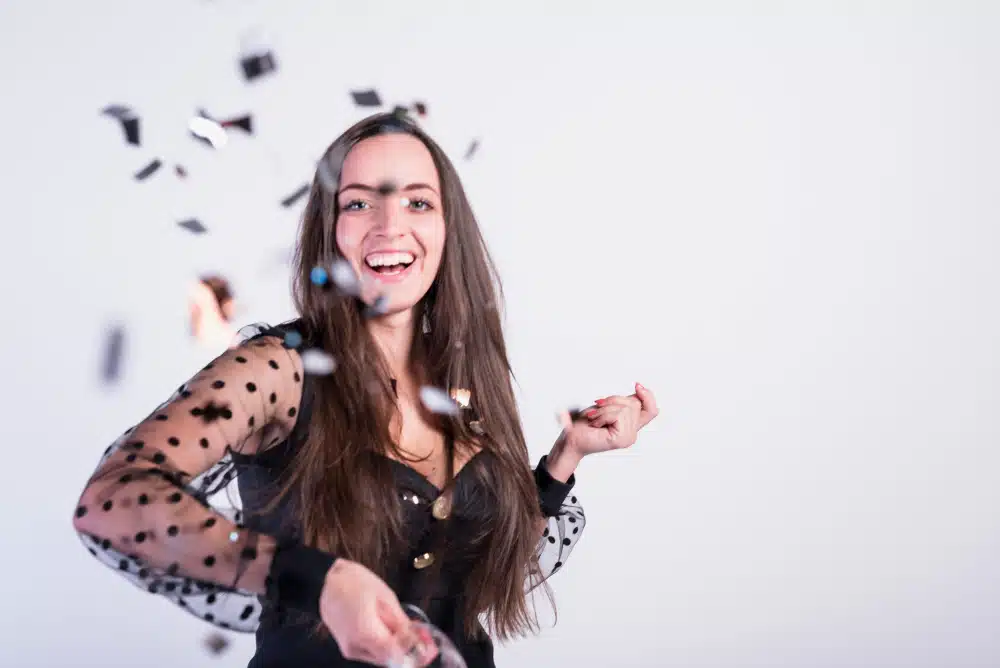 Mulher sorrindo confete por passar em um concurso