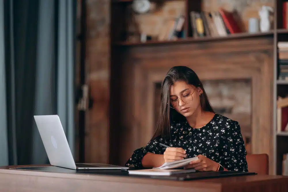 Mulher com livros em seus estudos para concursos